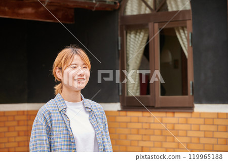 一個微笑的女人在一座古老的民宅、日本鄉村花園前 119965188