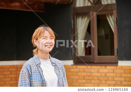 一個微笑的女人在一座古老的民宅、日本鄉村花園前 119965189