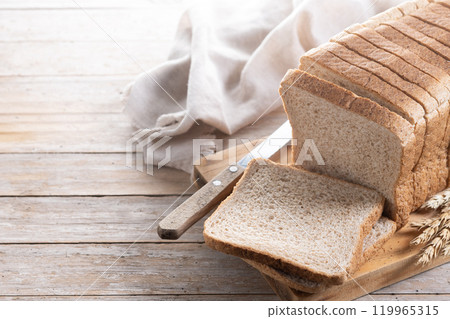 Healthy wholemeal bread slices on rustic wooden table 119965315