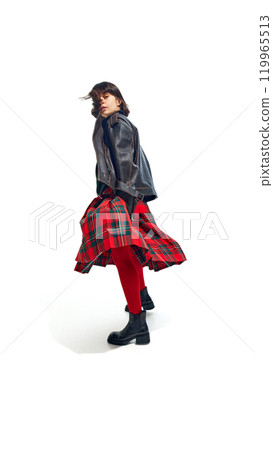 Stylish woman wearing leather jacket and red tights with plaid skirt, striking casual pose against white studio background. Stylish woman wearing leather jacket and red tights with plaid skirt, striking casual pose against white studio background. 119965513