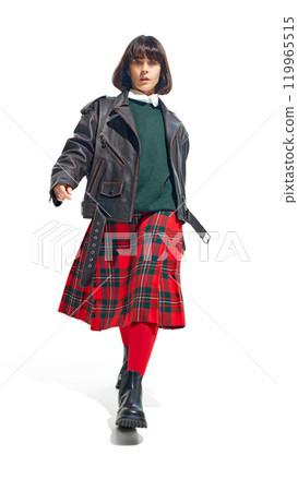 Young woman in leather jacket paired with green sweater and plaid skirt, exuding rebellious yet classic fashion sense against white studio background. Young woman in leather jacket paired with green sweater and plaid skirt, exuding rebellious yet classic fashion sense against white studio background. 119965515