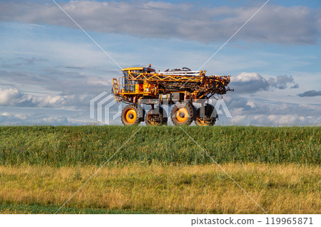 agricultural sprayer machine rolls along a rural road 119965871