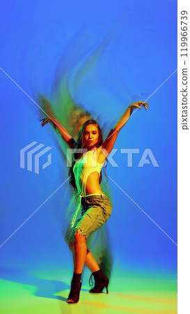 Creative design. Beautiful young woman dancing with passion and elegance high heel dance on gradient blue green background with abstract light effect. Creative design. Beautiful young woman dancing with passion and elegance high heel dance on gradient blue green background with abstract light effect. 119966739
