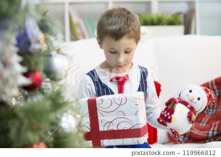 A boy with a Christmas gift.Get a gift for Christmas. The child received a gift A boy with a Christmas gift.Get a gift for Christmas. The child received a gift 119966812