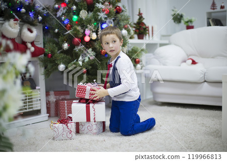 A boy with a New Year's gift. Curiosities. Christmas present for son A boy with a New Year's gift. Curiosities. Christmas present for son 119966813
