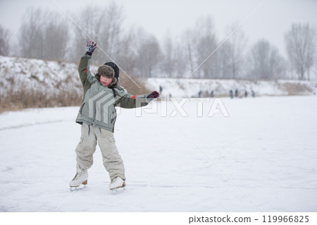 The kid learn to skate. The boy on the lake in winter snowy day on skates. Skating on the lake The kid learn to skate. The boy on the lake in winter snowy day on skates. Skating on the lake 119966825