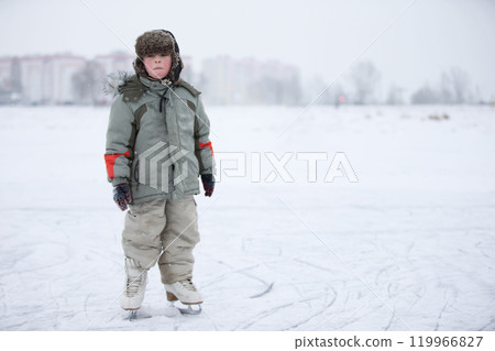 A child is a boy on skates on a snowy lake. Learn to ride A child is a boy on skates on a snowy lake. Learn to ride 119966827