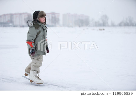 Ice skating boy on the lake.The boy is skating on the lake. Little baby in huge skates Ice skating boy on the lake.The boy is skating on the lake. Little baby in huge skates 119966829