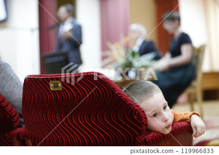 The child is a spectator at a concert which is boring. Uninteresting view 119966833