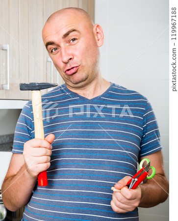 Man posing with hammer in his hands Man posing with hammer in his hands 119967188