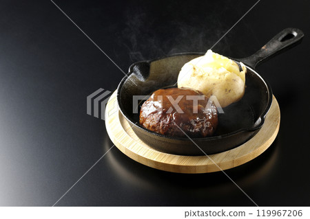 Hot hamburger steak and hot buttered potatoes photographed against a black background Hot hamburger steak and hot buttered potatoes photographed against a black background 119967206