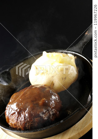 Hot hamburger steak and hot buttered potatoes photographed against a black background 119967226