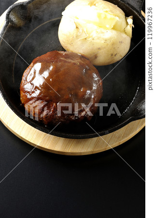 Hot hamburger steak and hot buttered potatoes photographed against a black background 119967236