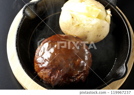Hot hamburger steak and hot buttered potatoes photographed against a black background Hot hamburger steak and hot buttered potatoes photographed against a black background 119967237