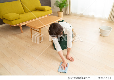 A middle-aged to senior woman wiping the floor with a damp cloth 119968344