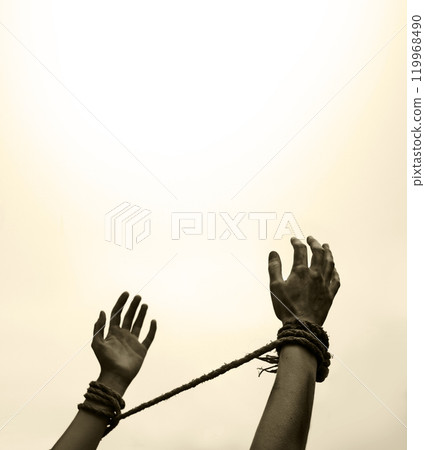 Tied hands raised to the sky 119968490