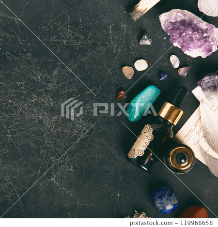 Healing Crystals and Essential Oil on Dark Textured Background 119968658