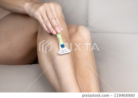 Woman shaves hairy legs with machine. photo Woman shaves hairy legs with machine. photo 119968980