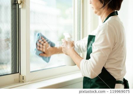 中高級婦女在家中清潔窗戶 中高級婦女在家中清潔窗戶 119969075