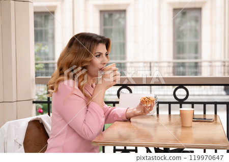 Woman Cafe Coffee Drink - A woman sits at a cafe table, drinking coffee and eating a pastry, enjoying a casual moment outdoors. Woman Cafe Coffee Drink - A woman sits at a cafe table, drinking coffee and eating a pastry, enjoying a casual moment outdoors. 119970647