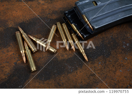 Ammunition with magazine on rusty metal 119970755