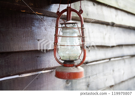 Antique rusty kerosene lantern on wooden wall. Antique rusty kerosene lantern on wooden wall. 119970807