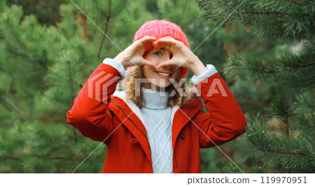 Winter portrait of happy smiling woman having fun enjoys snow against Christmas tree Winter portrait of happy smiling woman having fun enjoys snow against Christmas tree 119970951