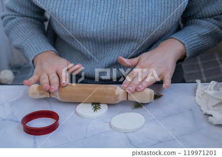 Creator is using white air dry clay for making decor to Christmas tree holiday. Creating hobby recreation activity that involves fingers. DIY crafting 119971201