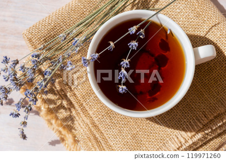 Lavender flowers with herbal cup of tea. Concept of Herbal medicine natural remedy. Organic relieving stress. Healthy beverage fresh delicious floral hot tea. Antispasmodic effect naturopathy Lavender flowers with herbal cup of tea. Concept of Herbal medicine natural remedy. Organic relieving stress. Healthy beverage fresh delicious floral hot tea. Antispasmodic effect naturopathy 119971260
