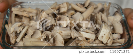 Unrecognizable woman showing into camera frozen food sliced mushrooms champignon homemade. Harvesting concept. Stocking up vegetables for winter storage Unrecognizable woman showing into camera frozen food sliced mushrooms champignon homemade. Harvesting concept. Stocking up vegetables for winter storage 119971271