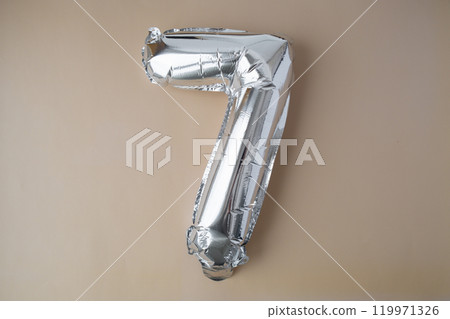 7 seven metallic balloon on beige neutral background. Greeting card silver foil balloon number Happy birthday holiday concept. Copy space for text. Celebration party congratulation 119971326