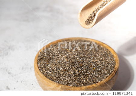 Chia seeds fall in wooden bowl. Healthy superfood rich in Omega 3 fatty acids. Dry healthy natural ingredient. Chia grains are falling 119971341