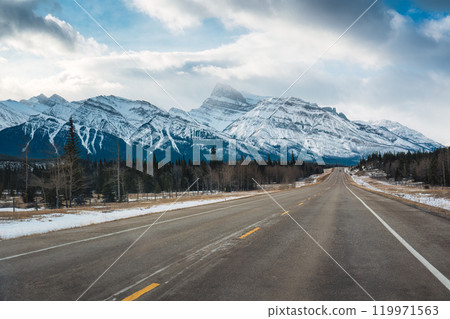 Road trip with on highway road with snow covered rocky mountains in winter at Kootenay plains area, Canada 119971563