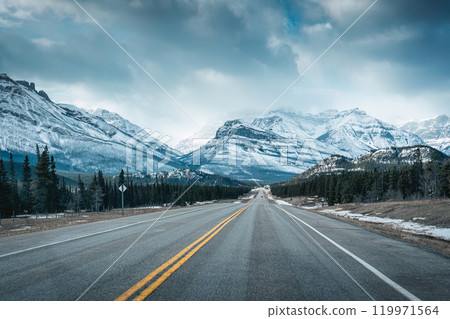 Road trip with on highway road with snow covered rocky mountains in winter at Kootenay plains area, Canada 119971564