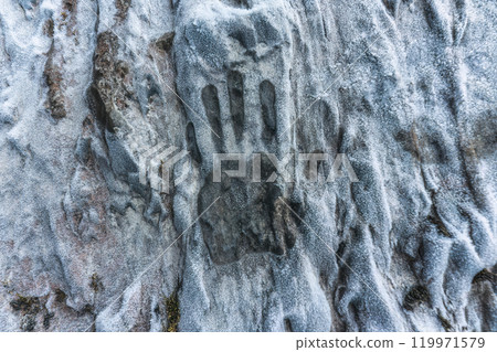 Caveman palm hand print on limestone wall in ice cave 119971579