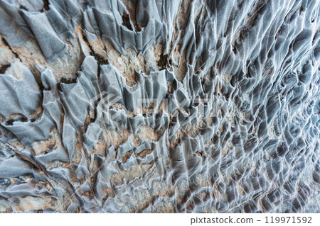 Abstract weathered rocky limestone mountain cave with lichen surface 119971592