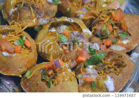 Close up to pani puri and its spicy and savory stuffing, authentic local nepali street food showing the culture and cuisine of Nepal Close up to pani puri and its spicy and savory stuffing, authentic local nepali street food showing the culture and cuisine of Nepal 119971687