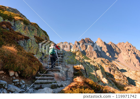 Couple hiker hiking on rocky mountain during track to Lac Blanc amidst the French alps 119971742