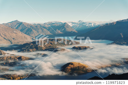 Scenic foggy mountain from summit of Roys Peak with Lake Wanaka in the morning at New Zealand 119971823