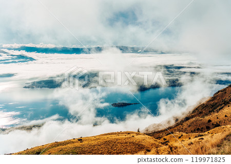Scenic foggy mountain from summit of Roys Peak with Lake Wanaka in the morning at New Zealand 119971825