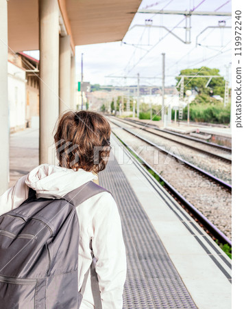 Young Person Waiting Alone at Train Station 119972240