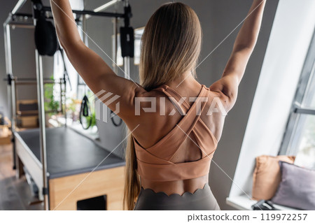 Pilates fitness trainer beautiful back relief. Pilates studio. Young sporty attractive woman wearing sportswear in yoga studio. Fit, healthy and strong authentical body. Fitness concept Pilates fitness trainer beautiful back relief. Pilates studio. Young sporty attractive woman wearing sportswear in yoga studio. Fit, healthy and strong authentical body. Fitness concept 119972257