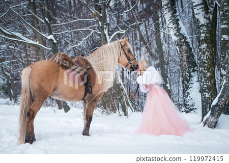 Princess in crown with horse in winter. Fairy tale, snowy queen 119972415