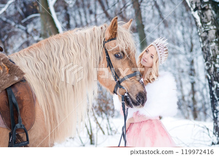 Princess in crown with horse in winter. Fairy tale, snowy queen 119972416