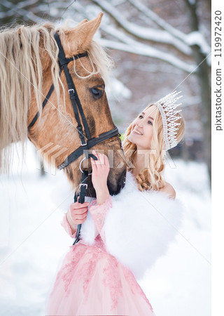 Princess in crown with horse in winter. Fairy tale, snowy queen Princess in crown with horse in winter. Fairy tale, snowy queen 119972420