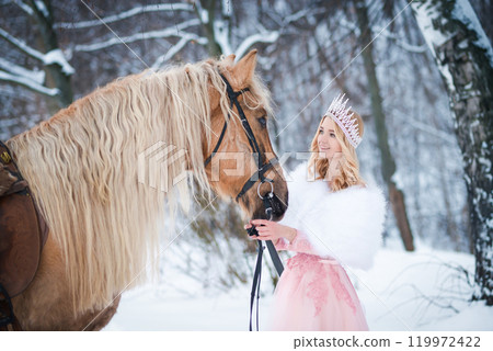 Princess in crown with horse in winter. Fairy tale, snowy queen 119972422