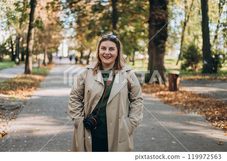 Happy woman photographer with camera walking outdoors. Hobby photographer concept. Urban lifestyle banner Happy woman photographer with camera walking outdoors. Hobby photographer concept. Urban lifestyle banner 119972563