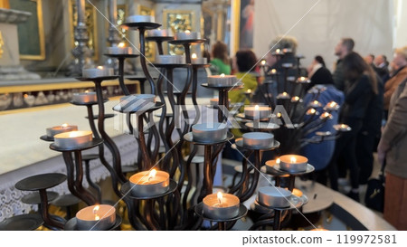 Burning candles in a Catholic church during the Divine Service. 119972581