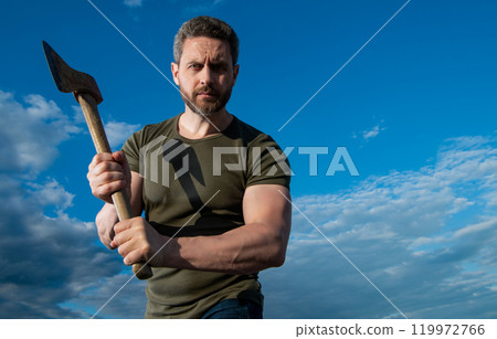 man threaten with axe. brutally man hold ax. brutal man on sky background 119972766