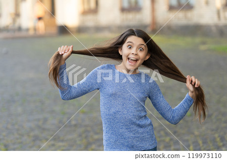 Having fun. Teen girl with long hair outdoor. Autumn fashion girl. Trendy and stylish teenager girl smiling. Fall fashion style for teen. Complete outfit style. Girl portrait in casual sweater 119973110